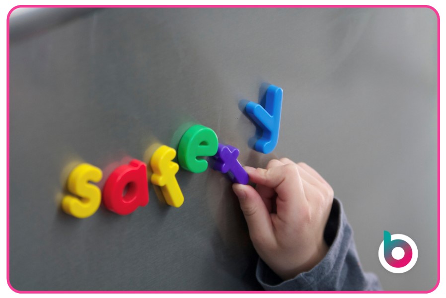 Safeguarding-in-Early-Years-image-child-putting-magnets-spelling-safety-on-metal-surface